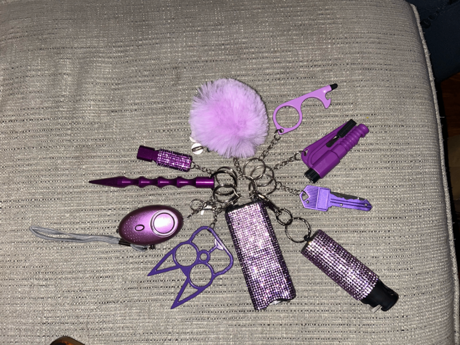 Fully loaded women's safety keychain bundle with stun gun, pepper spray, alarm, claw, pom pom, whistle, window breaker and accessories